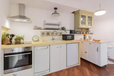 a kitchen with white cabinets and a sink at Fienaroli in Trastevere in Rome