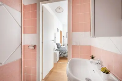 a bathroom with a white tub and pink tiles at Studio basic nice&comfortable in Rome