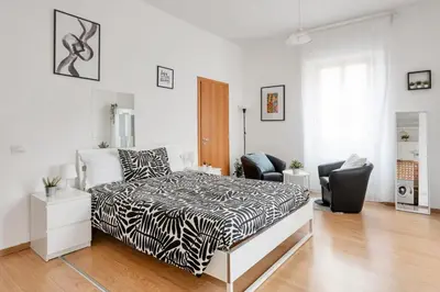 a bedroom with a black and white bed and chairs at Studio basic nice&comfortable in Rome