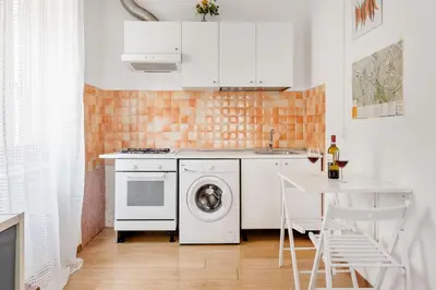 a kitchen with a washing machine and a table at Studio basic nice&comfortable in Rome