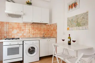 a kitchen with a washing machine and a table with wine glasses at Studio basic nice&comfortable in Rome