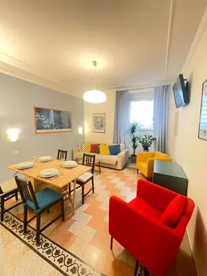 a living room with a table and a red chair at Celio west side apartment in Rome