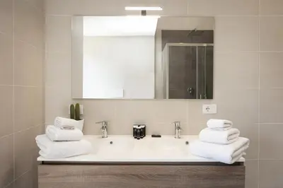 a bathroom with a sink and a mirror and towels at Amazing Colosseo in Rome