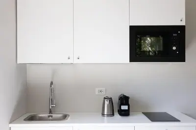 a white kitchen with a sink and a microwave at Amazing Colosseo in Rome