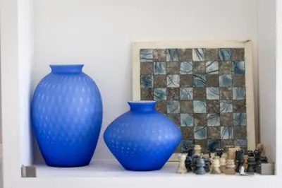 two blue vases sitting on a shelf next to a chess board at Amazing Colosseo in Rome