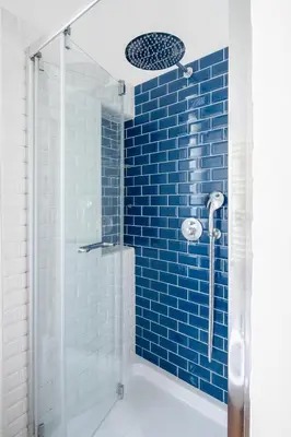 a blue tiled shower with a glass shower backdoor at Botanical Home close Vatican in Rome