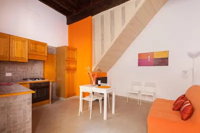 a kitchen with a table and chairs in a room at Boccanera a Trastevere Holiday Apartment in Rome