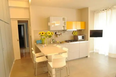 a kitchen with a table with chairs and a vase of flowers at Saint Peter's House in Rome