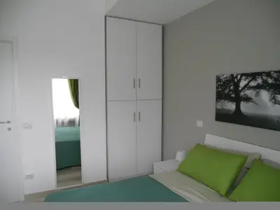 a bedroom with white cabinets and a green bed at Saint Peter's House in Rome