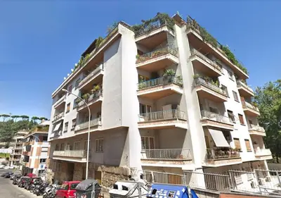 a tall white building with plants on it at Saint Peter's House in Rome