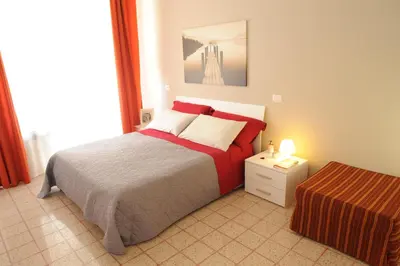 a bedroom with a bed with a red and gray blanket at Saint Peter's House in Rome
