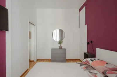 a bedroom with a bed and a purple wall at La Casa Di Rinny - Vaticano in Rome