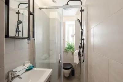 a white bathroom with a sink and a shower at La Casa Di Rinny - Vaticano in Rome
