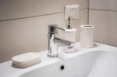 a bathroom sink with a faucet and some toiletries at Locazione turistica via degli spagnoli in Rome