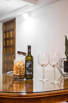 a bottle of wine and two wine glasses on a table at Locazione turistica via degli spagnoli in Rome