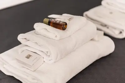 a pile of towels with a bottle on top at Locazione turistica via degli spagnoli in Rome