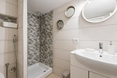 a bathroom with a shower and a sink and a mirror at Locazione turistica via degli spagnoli in Rome