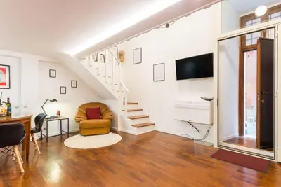 a living room with a staircase and a chair at Locazione turistica via degli spagnoli in Rome