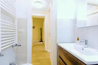 a white bathroom with a sink and a toilet at Elegantis Milos Suite Apartment - Your Chic Retreat in Central Rome in Rome