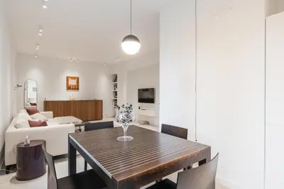 a dining room and living room with a table and chairs at GuestHost - Pannonia Colosseum in Rome