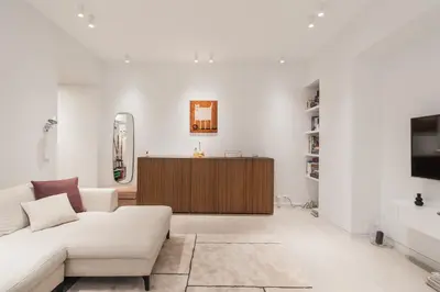 a white living room with a couch and a tv at GuestHost - Pannonia Colosseum in Rome