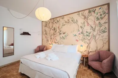 a bedroom with a bed and two chairs at Basilica San Paolo - Luxurious penthouse with Wi-Fi in Rome