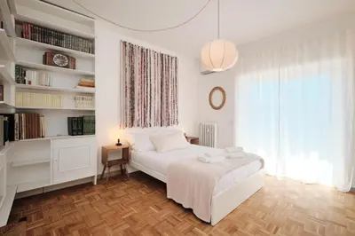 a white bedroom with a bed and a book shelf at Basilica San Paolo - Luxurious penthouse with Wi-Fi in Rome