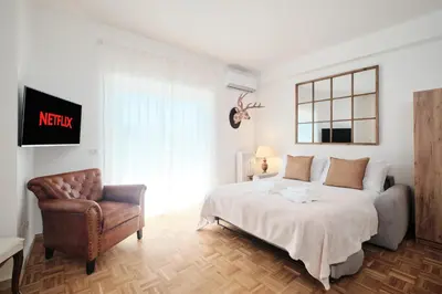 a bedroom with a king sized bed and a chair at Basilica San Paolo - Luxurious penthouse with Wi-Fi in Rome