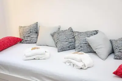 a white couch with pillows and towels on it at Jenner Apartment by Rental in Rome in Rome