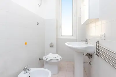 a white bathroom with a toilet and a sink at Jenner Apartment by Rental in Rome in Rome