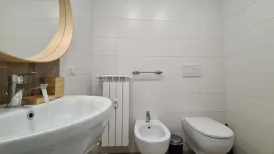 a white bathroom with a toilet and a sink at LoveRhome Apartment 14 in Rome