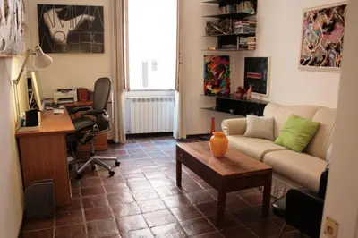 a living room with a couch and a desk at Baccina cozy apartment in Rome