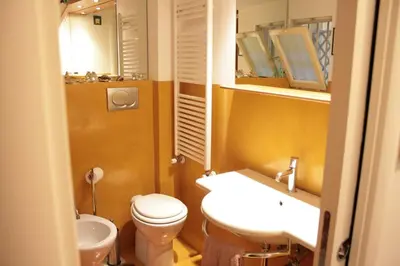 a bathroom with a toilet and a sink and a mirror at Baccina cozy apartment in Rome