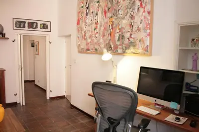 a desk with a computer and a chair in a room at Baccina cozy apartment in Rome