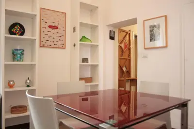a dining room with a glass table and white chairs at Baccina cozy apartment in Rome