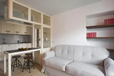 a living room with a white couch and a kitchen at Laurina F3 terrace for family - LOCAPPART in Rome
