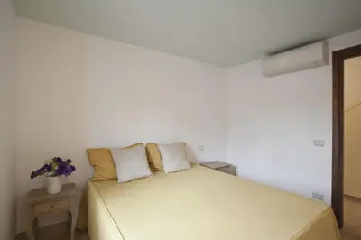 a white bedroom with a bed with two pillows at Laurina F3 terrace for family - LOCAPPART in Rome