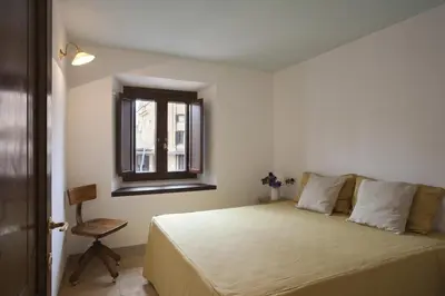 a bedroom with a bed with a window and a chair at Laurina F3 terrace for family - LOCAPPART in Rome