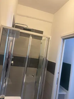 a shower with a glass door in a bathroom at PORTA FURBA Suites in Rome