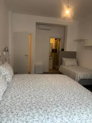 a bedroom with two beds in a room at PORTA FURBA Suites in Rome