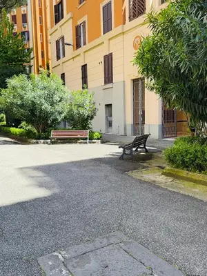 a park bench sitting in front of a building at Vacanze Romane a San Giovanni in Rome