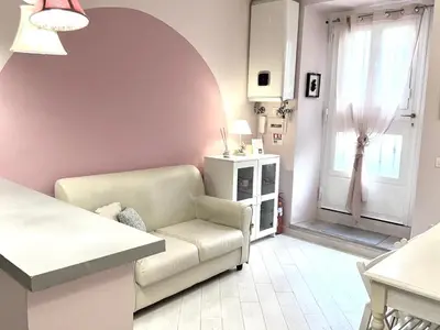a living room with a couch and a chair and a window at Vacanze Romane a San Giovanni in Rome