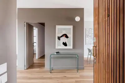 a hallway with a glass table and a picture of a penguin at The Best Rent - Spacious three-bedroom flat in the San Giovanni area in Rome