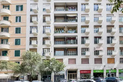 an apartment building with windows and cars parked in front at The Best Rent - Spacious three-bedroom flat in the San Giovanni area in Rome