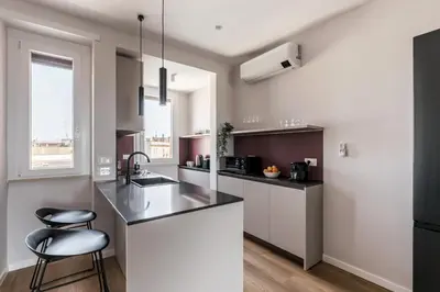 a kitchen with a counter and a chair in it at The Best Rent - Spacious three-bedroom flat in the San Giovanni area in Rome