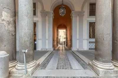 a hallway of a building with columns at Palazzo Borghese, a Burghesius home in Rome