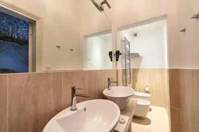 a bathroom with two sinks and a mirror at Palazzo Borghese, a Burghesius home in Rome