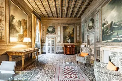 a room with paintings on the walls and a table at Palazzo Borghese, a Burghesius home in Rome