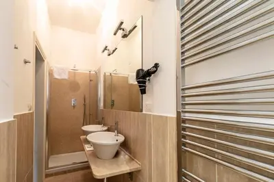 a bathroom with two sinks and a mirror at Palazzo Borghese, a Burghesius home in Rome