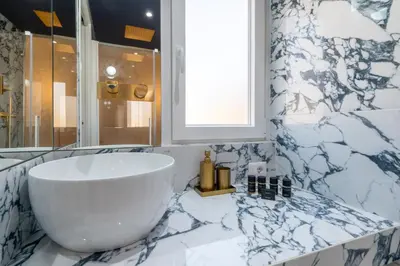 a bathroom with a large white tub and a window at Restart Accommodations Colonna e Ludovisi in Rome